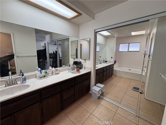 bathroom featuring tile patterned flooring, vanity, a bathtub, and a textured ceiling