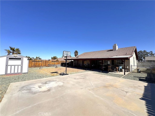 exterior space with a storage shed, a chimney, a tiled roof, a fenced backyard, and an outdoor structure