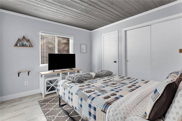 bedroom featuring crown molding, a closet, wood ceiling, and light hardwood / wood-style floors