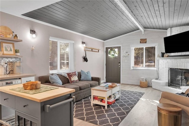 living room with dark wood-type flooring, vaulted ceiling with beams, a fireplace, and wooden ceiling