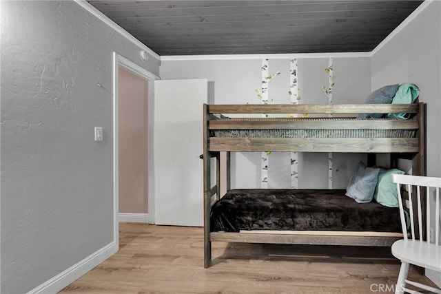 bedroom with hardwood / wood-style flooring, crown molding, and wooden ceiling