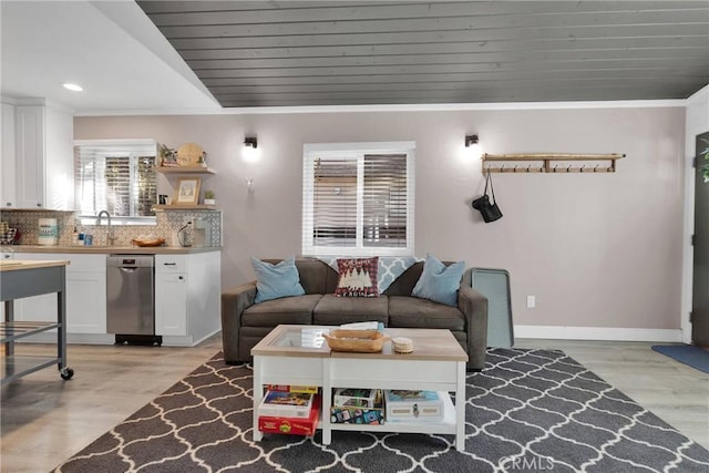 living room featuring sink, light hardwood / wood-style flooring, and wooden ceiling