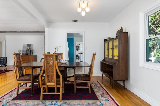 dining room with stacked washer and dryer and wood-type flooring