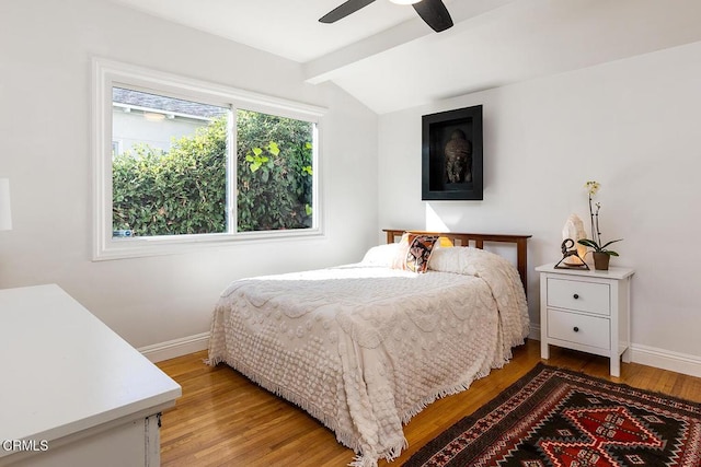 bedroom with ceiling fan, wood-type flooring, and vaulted ceiling with beams