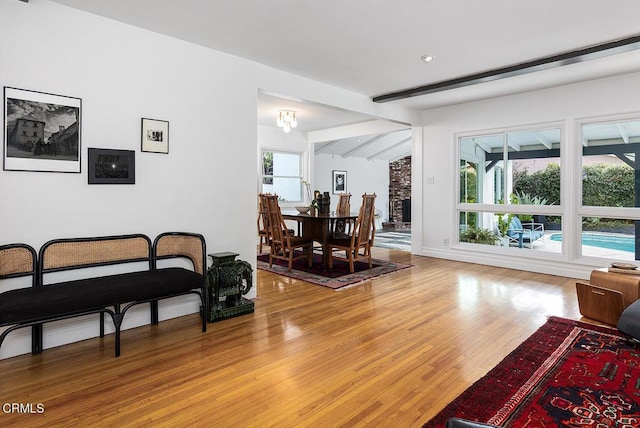 living room with hardwood / wood-style flooring and lofted ceiling with beams