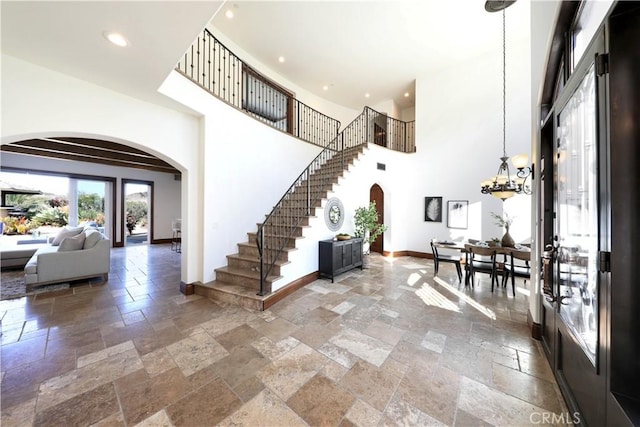 foyer featuring an inviting chandelier and a high ceiling