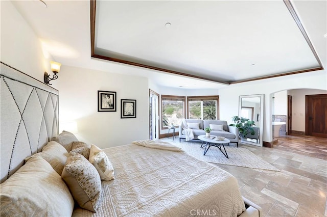 bedroom with ensuite bath and a raised ceiling