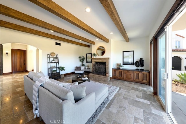 living room with beamed ceiling and a fireplace