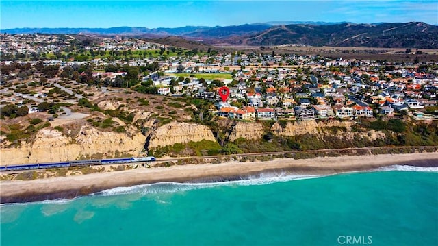 bird's eye view featuring a view of the beach and a water and mountain view