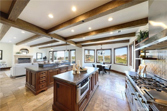 kitchen featuring beamed ceiling, tasteful backsplash, a center island, pendant lighting, and range hood