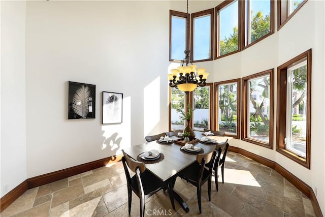 dining space featuring a notable chandelier and a high ceiling