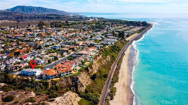 birds eye view of property with a water and mountain view and a beach view