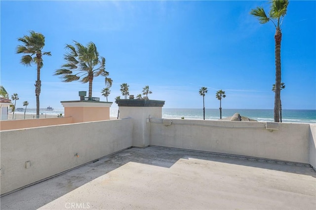 view of patio / terrace featuring a water view and a view of the beach