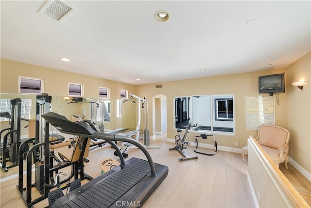 exercise room with light hardwood / wood-style floors