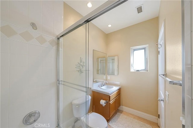 bathroom with a shower with door, vanity, and toilet