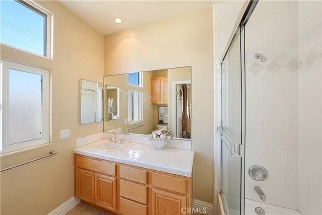 bathroom with enclosed tub / shower combo and vanity