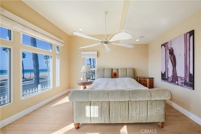 bedroom featuring a water view, ceiling fan, and light hardwood / wood-style floors