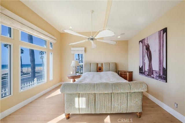 bedroom with ceiling fan, a water view, and light hardwood / wood-style floors