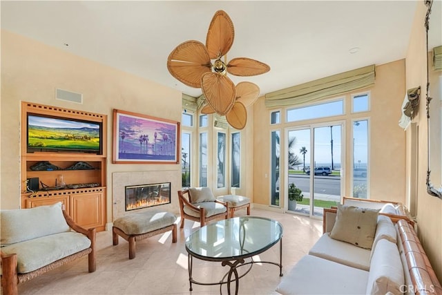 living area featuring light tile patterned floors and ceiling fan