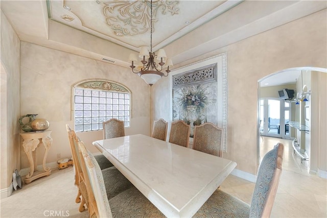 tiled dining area featuring a raised ceiling