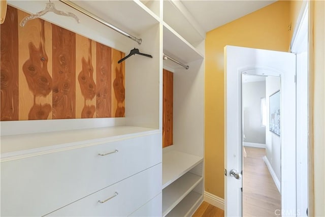 walk in closet featuring lofted ceiling and light hardwood / wood-style flooring