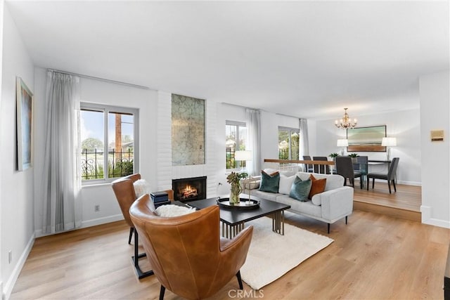 living room featuring a wealth of natural light, a fireplace, and light hardwood / wood-style flooring