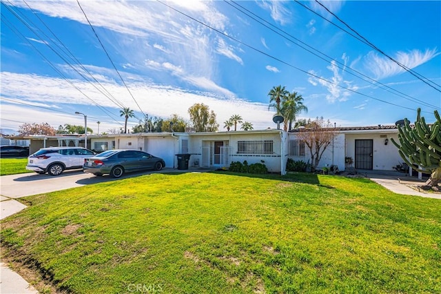 ranch-style home with driveway, a front yard, and stucco siding