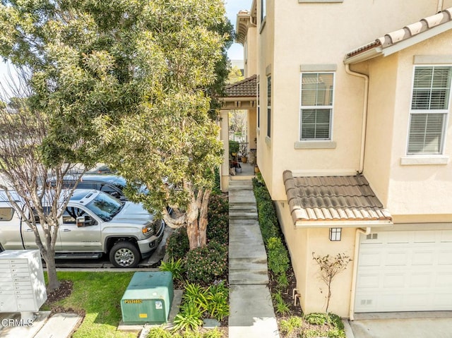 exterior space with a tile roof and stucco siding