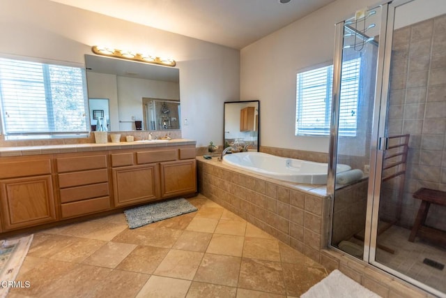 bathroom featuring a bath, tile patterned flooring, a shower stall, and vanity