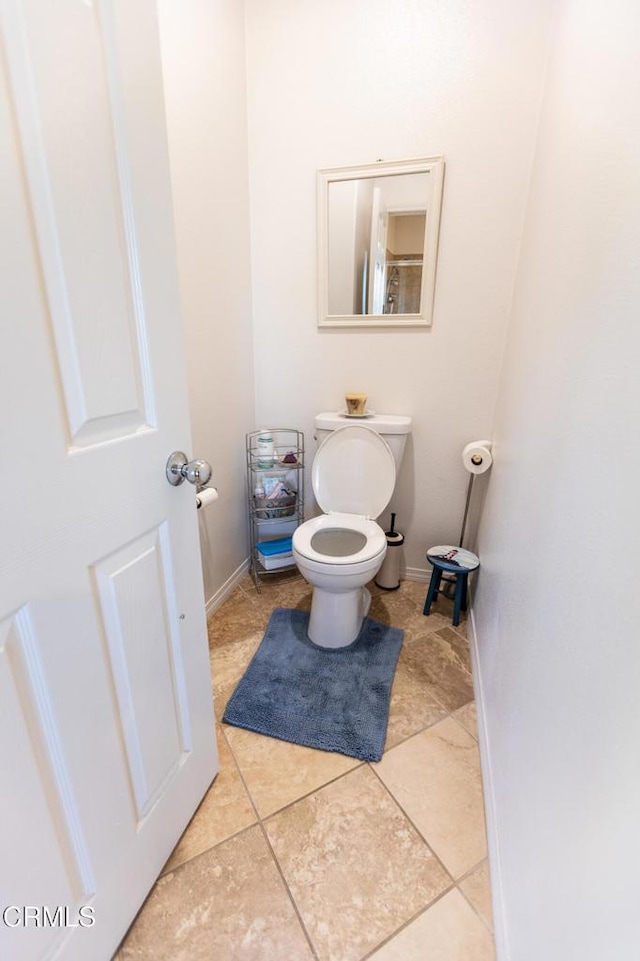 bathroom with baseboards, toilet, and tile patterned floors