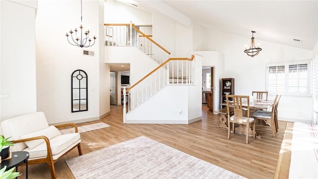 dining space with stairway, wood finished floors, visible vents, and a notable chandelier