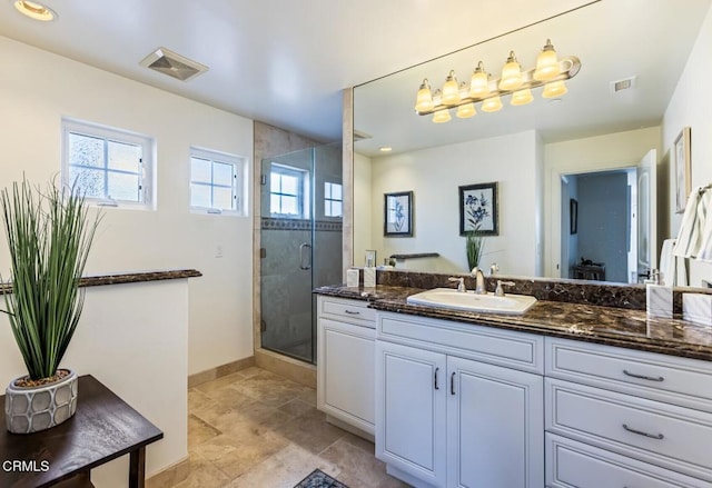 bathroom with vanity, plenty of natural light, and walk in shower