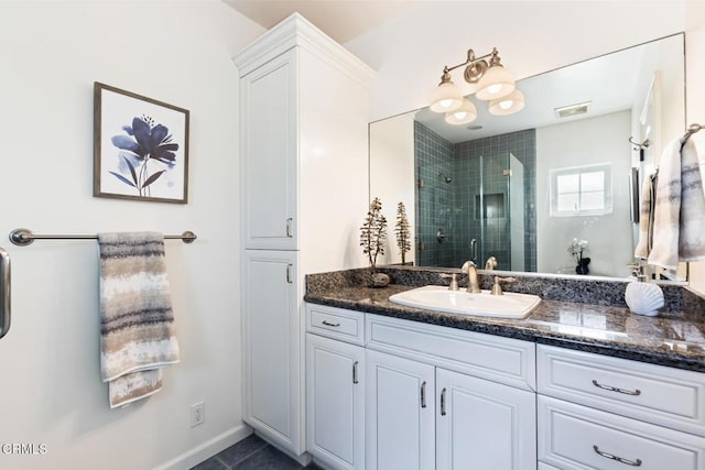 bathroom featuring vanity, a shower with shower door, and tile patterned floors