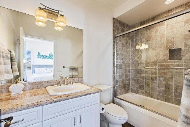 full bathroom featuring vanity, toilet, and bath / shower combo with glass door