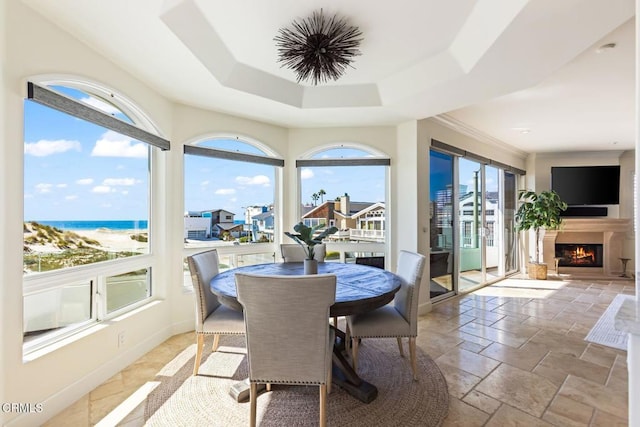 sunroom / solarium with a water view and a raised ceiling