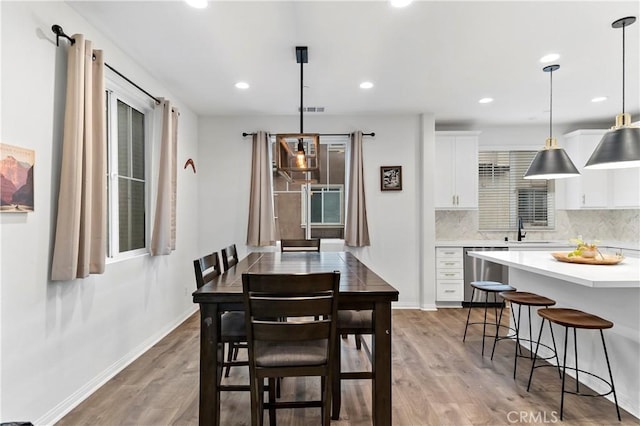 dining space with sink and light hardwood / wood-style flooring