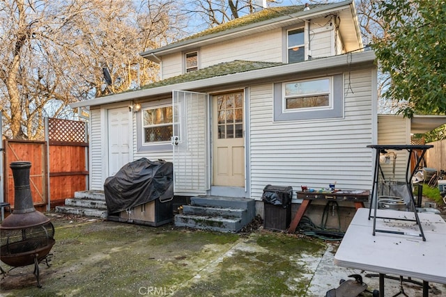 back of house with a fire pit