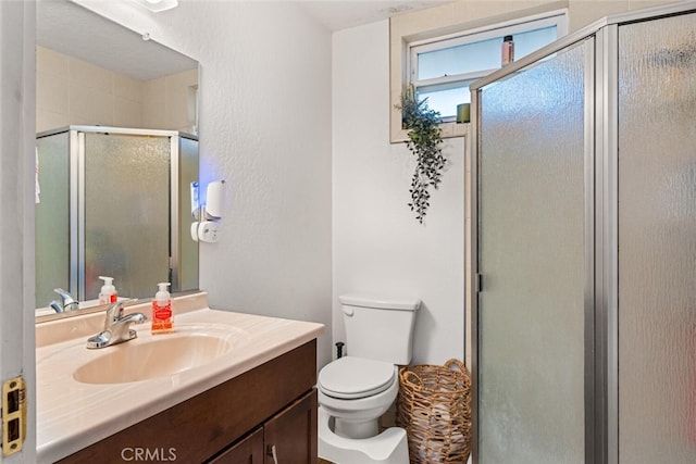 bathroom with toilet, vanity, and walk in shower