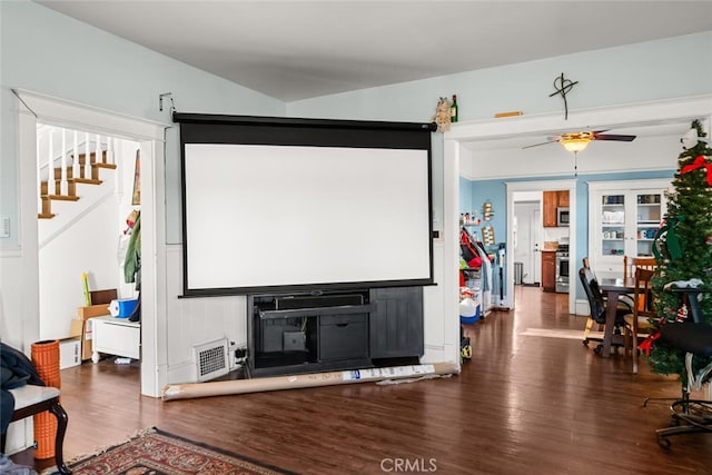 home theater room with dark hardwood / wood-style flooring, a fireplace, and ceiling fan