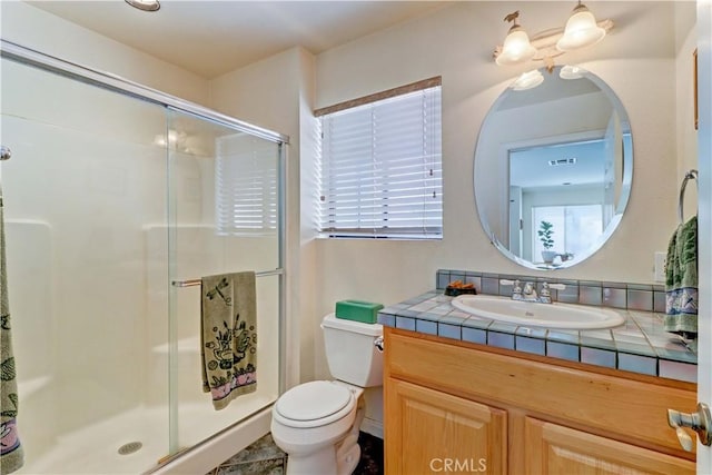 full bath featuring toilet, a stall shower, and vanity