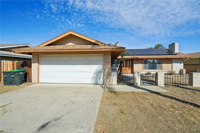 ranch-style home with a garage and solar panels