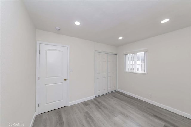 unfurnished bedroom featuring light hardwood / wood-style floors and a closet