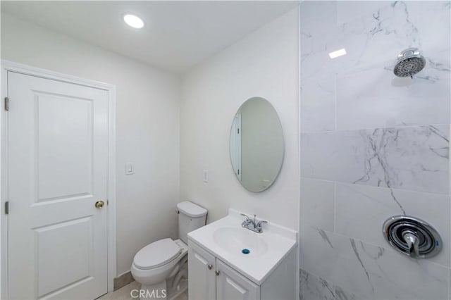 bathroom featuring vanity, toilet, and a tile shower