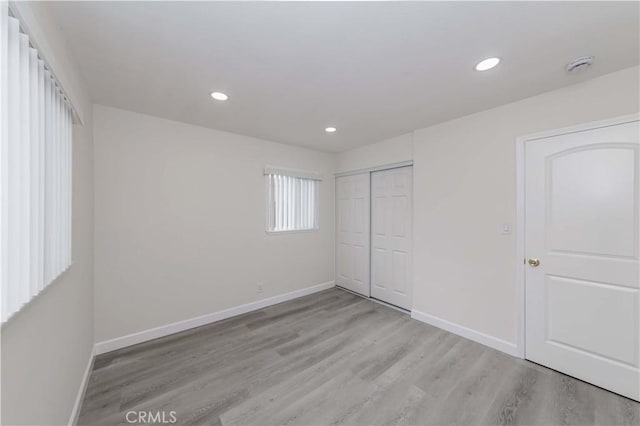 unfurnished bedroom with light hardwood / wood-style floors and a closet