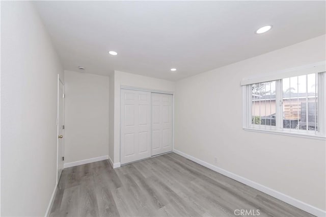 unfurnished bedroom with light hardwood / wood-style floors and a closet