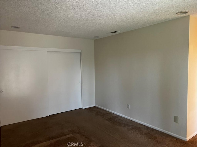 carpeted empty room with a textured ceiling