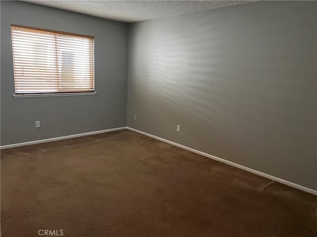 carpeted spare room with a textured ceiling