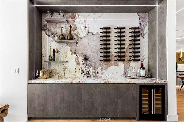 bar featuring hardwood / wood-style flooring and beverage cooler