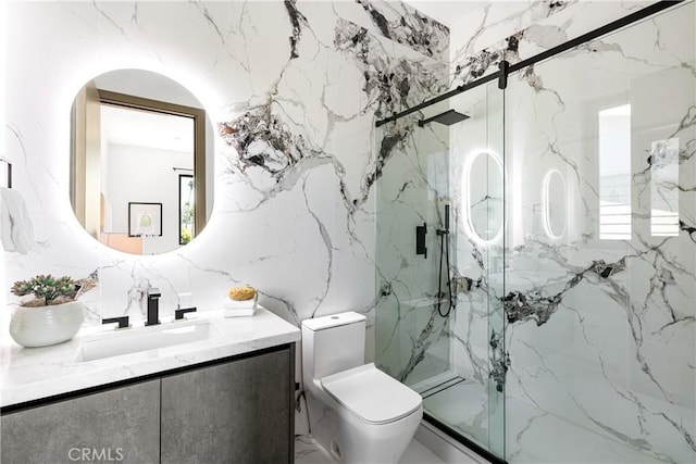 bathroom featuring vanity, a shower with shower door, and toilet