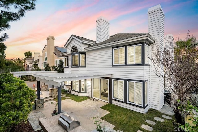 back of property with a patio area, a chimney, and a pergola